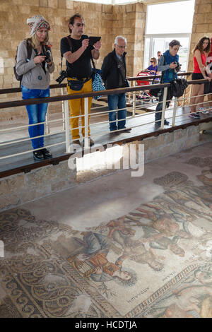 I turisti fotografare un mosaico romano di Appolo e Marsia, casa di Aion, Paphos parco archeologico, Cipro Foto Stock