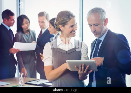 Imprenditore e imprenditrice utilizzando tavoletta digitale insieme Foto Stock