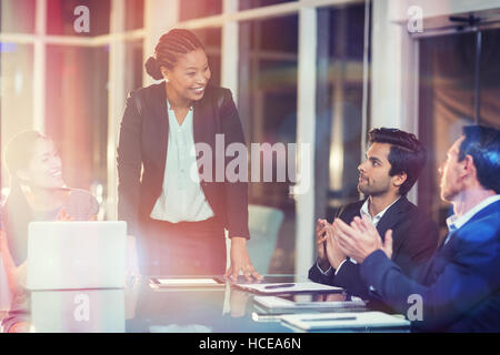 I colleghi ad applaudire collega dopo la presentazione Foto Stock