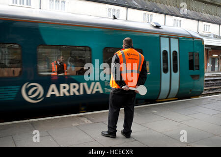 Guardia circa a wave off Galles arriva in treno, la stazione di Shrewsbury è a Foto Stock