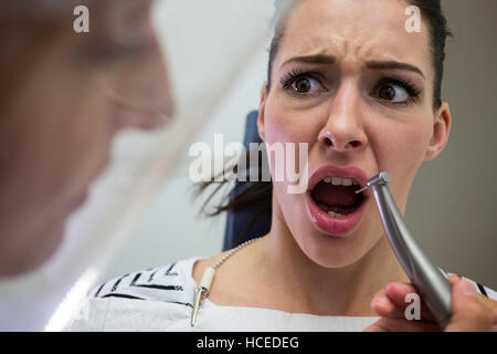 Giovane donna spaventata durante un dentista di check-up Foto Stock