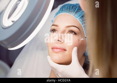 Giovane donna la ricezione di botox iniezione sul suo viso Foto Stock