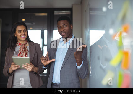 Imprenditore discutendo sulla lavagna bianca con un collega Foto Stock