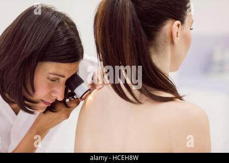 Il dermatologo esaminando la pelle del paziente con dermatoscope Foto Stock