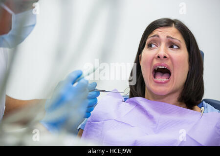 Paziente femmina spaventata durante un dentista di check-up Foto Stock