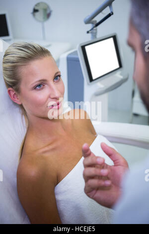 Paziente di sesso femminile che giace e guardando il medico Foto Stock