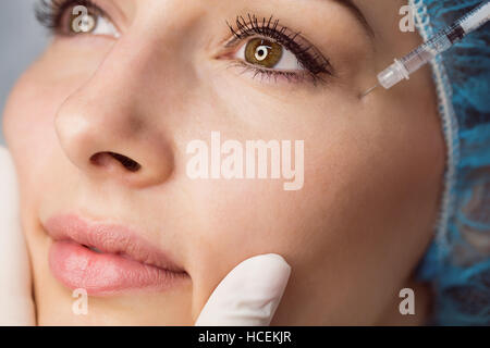 Giovane donna la ricezione di botox iniezione sul suo viso Foto Stock