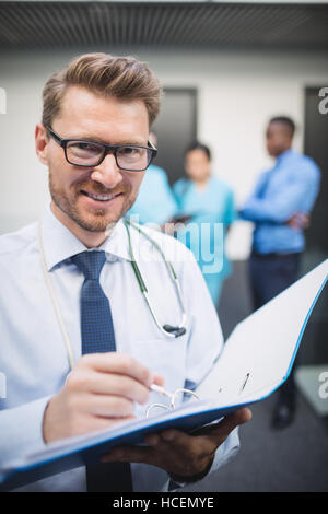 Medico a scrivere una relazione medica Foto Stock