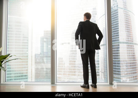 Lunghezza piena vista posteriore di imprenditore di successo nella grande città Foto Stock