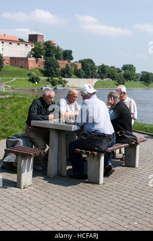 Un gruppo di anziani locali a giocare una partita a scacchi in un parco a Cracovia in Polonia Foto Stock
