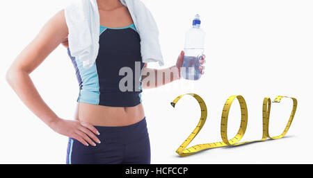 Immagine composita della sezione mediana di sportivo da donna con asciugamano attorno al collo e una bottiglia d'acqua Foto Stock