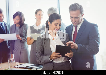 Imprenditore e imprenditrice utilizzando tavoletta digitale Foto Stock