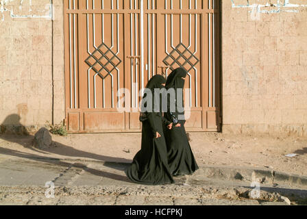 Sana, Yemen - 3 Gennaio 2008: le donne indossano il burqa e camminare sulla strada della vecchia Sana, Yemen Foto Stock