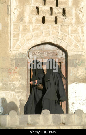 Sana, Yemen - 19 Gennaio 2008: le donne indossano il burqa e camminare sulla strada della vecchia Sana, Yemen Foto Stock