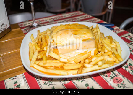 "Francesinha' bistecca, il salame chorizo e formaggio sandwich tostato con salsa saporita, servita con chips, Ribeira, Porto, Portogallo Foto Stock