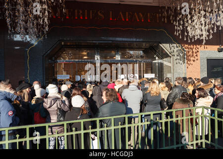 La folla di gente che aspetta la domenica mattina apertura delle Galeries Lafayette di Parigi Foto Stock