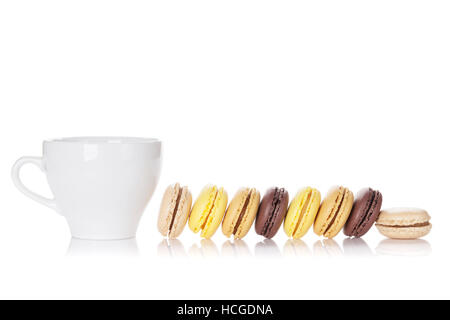 Amaretti colorati e tazza di bevanda. Dolce macarons. Isolato su sfondo bianco Foto Stock