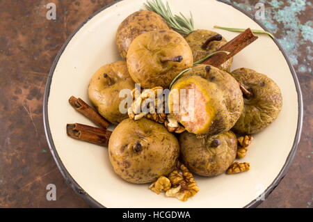 Bollito di pere selvatiche con noci e cannella su una piastra Foto Stock