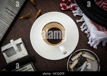 Dopo il caffè la mattina Giordana con carta di notizie e di sigarette Foto Stock