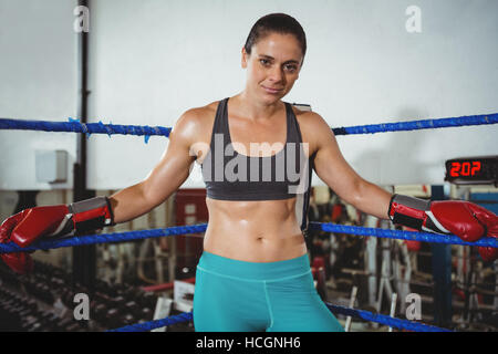 Fiducioso boxer femmina appoggiato su di pugilato ring Foto Stock