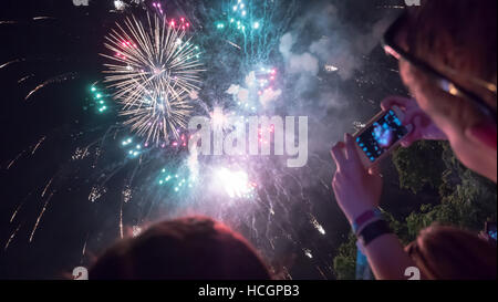 Donna godendo di fuochi d'artificio di celebrazione e di scattare foto Foto Stock