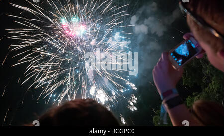 Donna godendo di fuochi d'artificio di celebrazione e di scattare foto Foto Stock