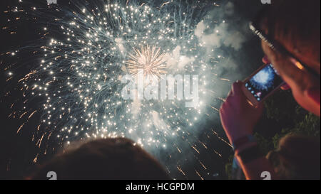 Donna godendo di fuochi d'artificio di celebrazione e di scattare foto Foto Stock