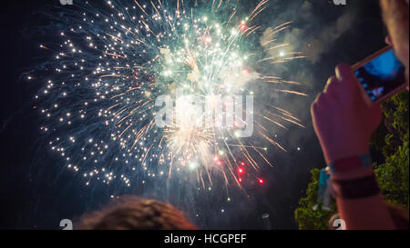 Donna godendo di fuochi d'artificio di celebrazione e di scattare foto Foto Stock