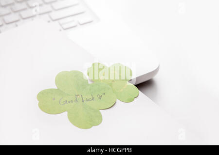 La carta e il computer notebook con quattro-foglia di trifoglio Foto Stock