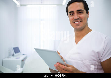 Dentista utilizzando una tavoletta digitale presso la clinica Foto Stock