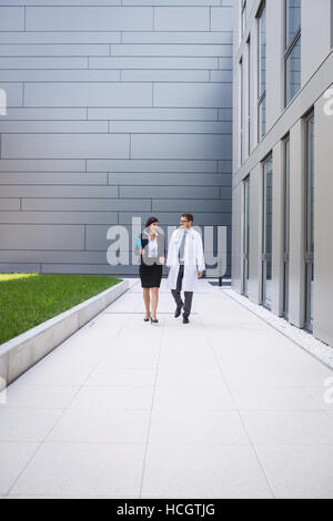 I medici interagire gli uni con gli altri mentre si cammina Foto Stock