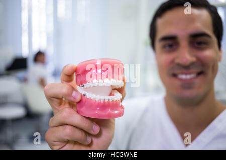 Ritratto di dentista tenendo una serie di protesi Foto Stock