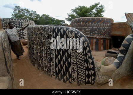 Il Burkina Faso, Po, villaggio Tiebele della tribù Kassena , capanne di argilla con geometrica dipinta in bianco & nero / modelli Dorf Tiebele der Kassena Ethie, bemalte Lehmhaeuser mit Mustern geometrischen in schwarz und weiss, die Wandbemalungen werden von den Kassena-Frauen gemacht. Sie benutzen dazu schwarze Farbe, die aus Graphitpulver und Wasser gemischt wird, sowie weisse Farbe, die Mit Hilfe von Specksteinen gewonnen wird. Die Farbe wird auf einen roten Untergrund aus Lehm, Wasser und Néré-Schoten aufgetragen. Als Motive dienen Muster und simboli, die entweder Alltagsleben dem oder der religioesen Symbo Foto Stock