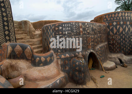 Il Burkina Faso, Po, villaggio Tiebele della tribù Kassena , capanne di argilla con geometrica dipinta in bianco & nero / modelli Dorf Tiebele der Kassena Ethie, bemalte Lehmhaeuser mit Mustern geometrischen in schwarz und weiss, die Wandbemalungen werden von den Kassena-Frauen gemacht. Sie benutzen dazu schwarze Farbe, die aus Graphitpulver und Wasser gemischt wird, sowie weisse Farbe, die Mit Hilfe von Specksteinen gewonnen wird. Die Farbe wird auf einen roten Untergrund aus Lehm, Wasser und Néré-Schoten aufgetragen. Als Motive dienen Muster und simboli, die entweder Alltagsleben dem oder der religioesen Symbo Foto Stock