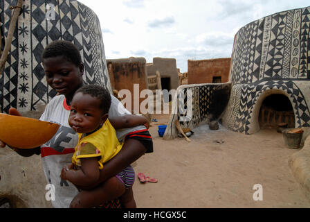 Il Burkina Faso, Po, villaggio Tiebele della tribù Kassena , capanne di argilla con geometrica dipinta in bianco & nero / modelli Dorf Tiebele der Kassena Ethie, bemalte Lehmhaeuser mit Mustern geometrischen in schwarz und weiss, die Wandbemalungen werden von den Kassena-Frauen gemacht. Sie benutzen dazu schwarze Farbe, die aus Graphitpulver und Wasser gemischt wird, sowie weisse Farbe, die Mit Hilfe von Specksteinen gewonnen wird. Die Farbe wird auf einen roten Untergrund aus Lehm, Wasser und Néré-Schoten aufgetragen. Als Motive dienen Muster und simboli, die entweder Alltagsleben dem oder der religioesen Symbo Foto Stock