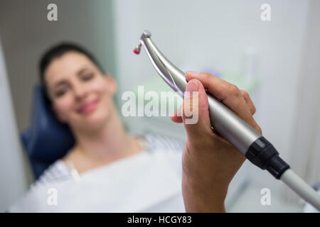 Close-up di dentista tenendo un odontoiatria, manipolo dentale mentre l'esame di una donna Foto Stock