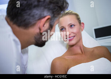 Paziente femmina di sorridere mentre guarda il medico Foto Stock