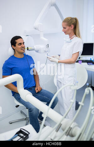 Dentista femmina tenendo x-ray di pazienti denti Foto Stock