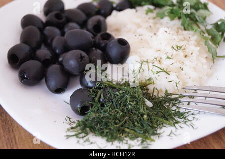 Macro Close-up vista deliziosa di riso con olive, aneto amd riso sulla piastra di Pentecoste con argento folk Foto Stock