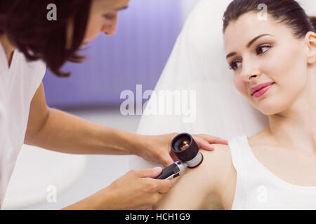 Il dermatologo esaminando la pelle del paziente con dermatoscope Foto Stock