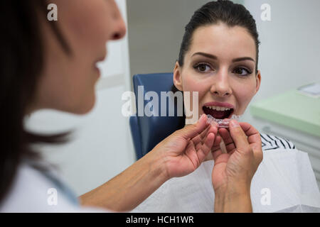 Dentista aiutare un paziente a indossare bretelle invisibile Foto Stock