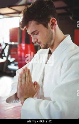 Il Karate player nella preghiera pongono Foto Stock