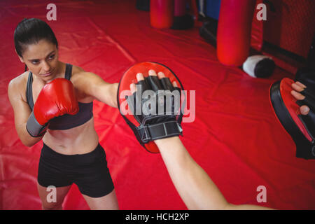 Boxer femmina praticando con trainer Foto Stock
