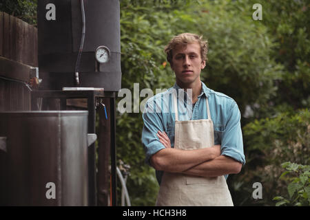 Uomo che indossa il grembiule permanente al birrificio home Foto Stock