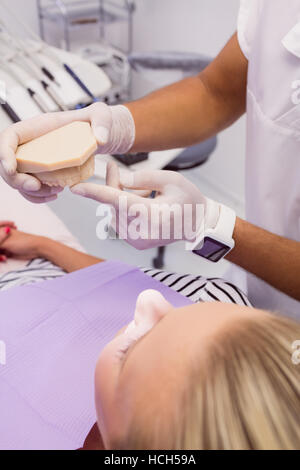 Dentista mostra di dentiera modello per il paziente Foto Stock