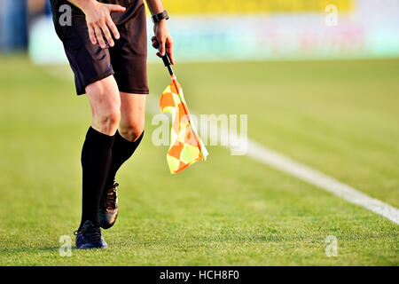 Arbitro assistente in movimento lungo il diversivo durante una partita di calcio Foto Stock