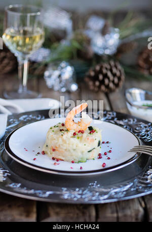 Scampi e zucchine risotto sul tavolo in legno con decorazioni di Natale Foto Stock