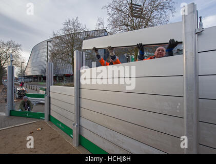 Bremen, Germania. 08 Dic, 2016. Lavoratori edili assemblare il nuovo proiettore mobile barriera di protezione durante una dimostrazione al di fuori lo stadio Weser di Brema, Germania, 08 dicembre 2016. La parete è progettato per potenziare una seconda parete permanente intorno al soccer stadium in caso di allagamenti. Foto: Ingo Wagner/dpa/Alamy Live News Foto Stock