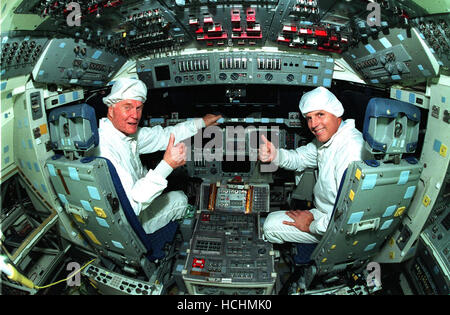 Stati Uniti il senatore John H. Glenn, Jr. (Democratico di Ohio), sinistra, gode di un tour del ponte di volo nell'orbiter Columbia con astronauta Stephen Oswald all'Orbiter Processing Facility 3 al Kennedy Space Center il 21 gennaio 1998. Il senatore Glenn arrivati al KSC il 7 gennaio 20 a tour KSC in aree operative e per visualizzare il lancio di STS-89 più tardi questa settimana. Glenn, che hanno fatto storia nel 1962 come il primo americano in orbita attorno alla Terra, completare tre orbite in un periodo di cinque ore di volo a bordo di amicizia 7, sarà in grado di volare la sua seconda missione spaziale a bordo della navetta spaziale Discovery questo ottobre. Glenn è il ritiro dalla Foto Stock