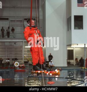 Stati Uniti il senatore John H. Glenn Jr. (Democratico di Ohio), STS-95 payload specialist, simula un paracadute caduta in acqua durante il salvataggio di emergenza di formazione presso il Sonny Carter Training Center del 8 ottobre 1998. Altri STS-95 Membri di equipaggio sono visti la distribuzione o utilizzando zattere di salvataggio in una spinta di galleggiamento neutra del laboratorio piscina in background. Credito: la NASA via CNP /MediaPunch Foto Stock